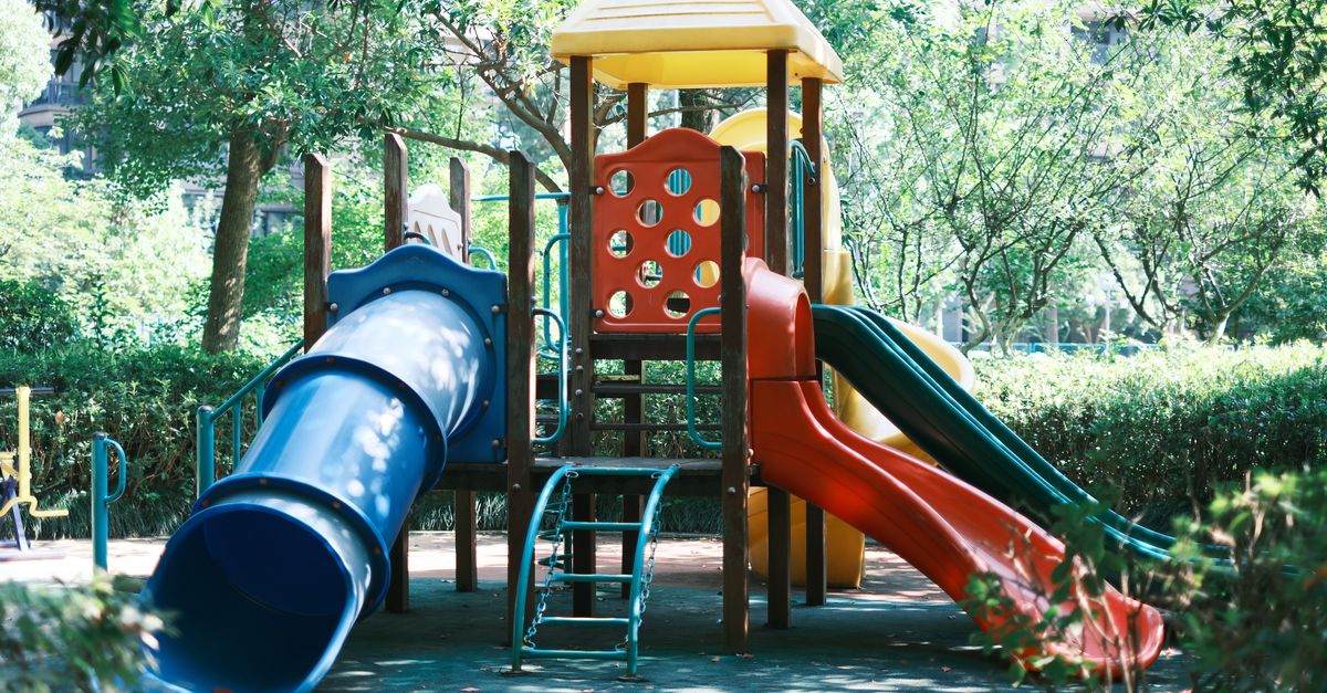 A vibrant playground slide set in a sunny park, perfect for children's outdoor fun.